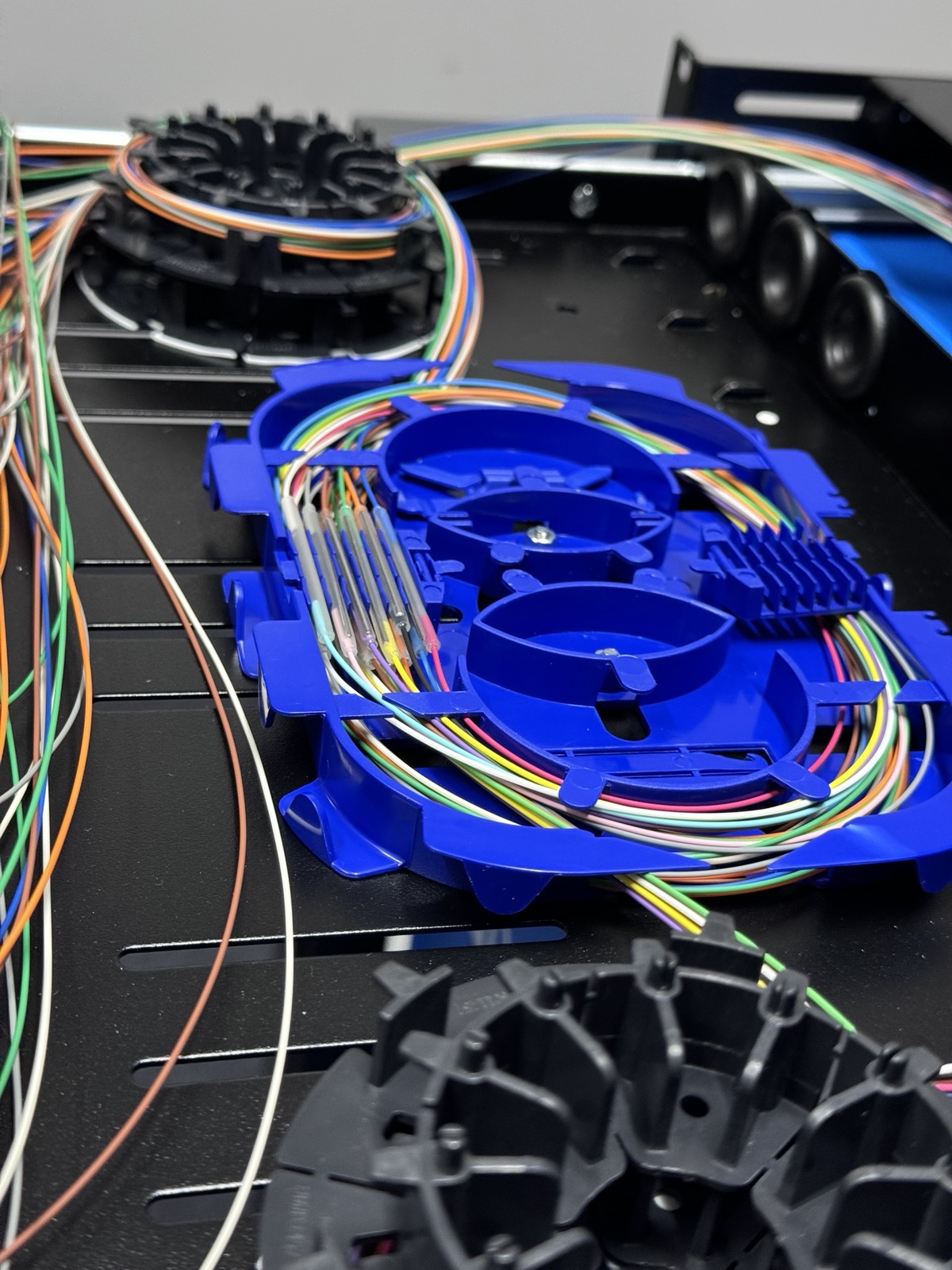 Fibre splice tray with heat-shrink protected joints.