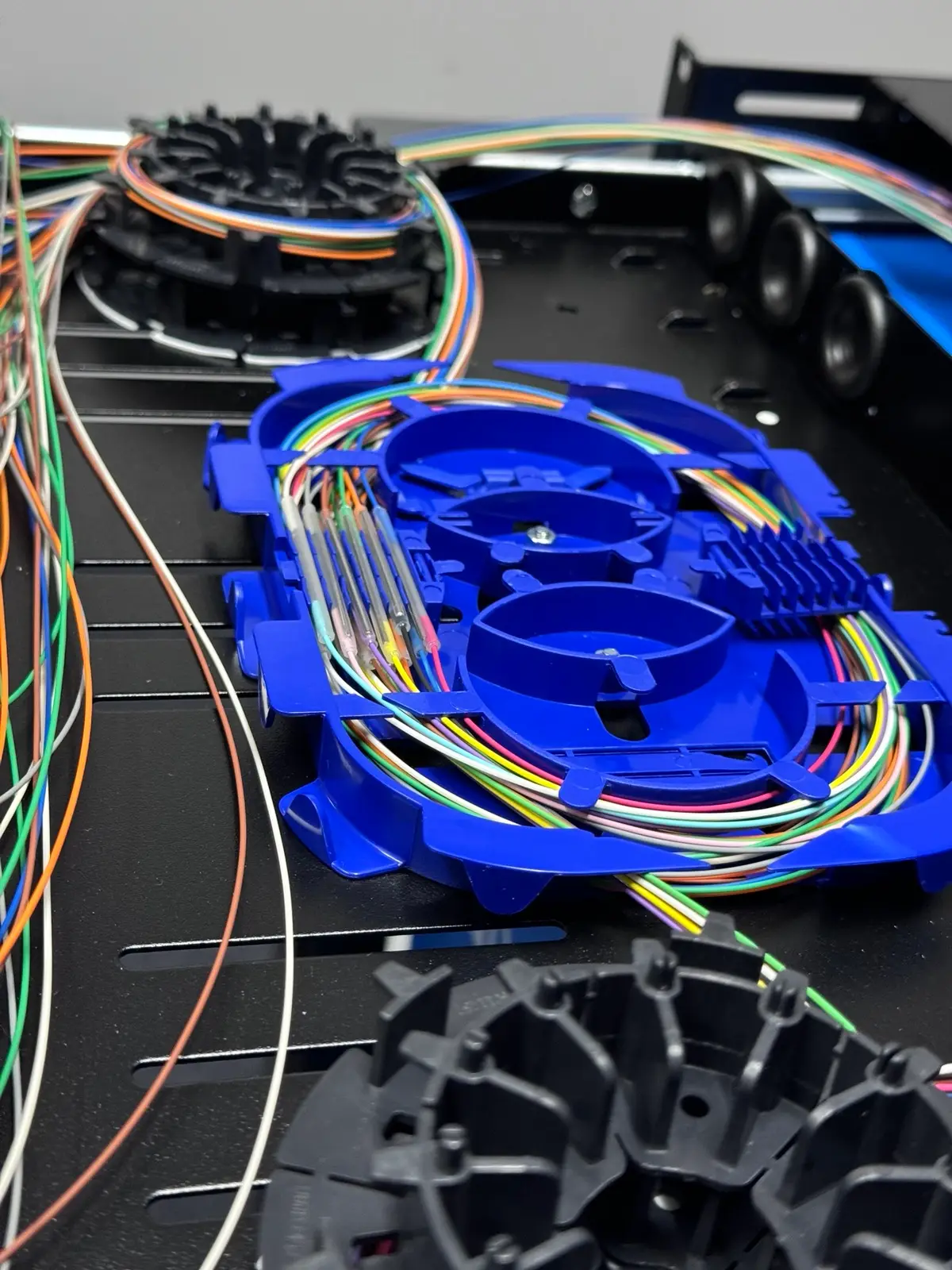 Fibre splice tray with heat-shrink protected joints.